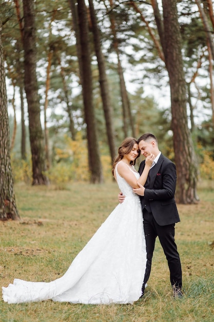 La novia y el novio corren por un bosque Sesión de fotos de boda