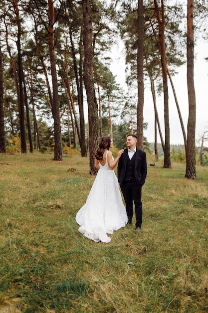 La novia y el novio corren por un bosque Sesión de fotos de boda