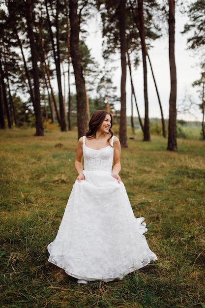 La novia y el novio corren por un bosque Sesión de fotos de boda