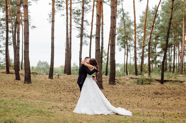 La novia y el novio corren por un bosque Sesión de fotos de boda