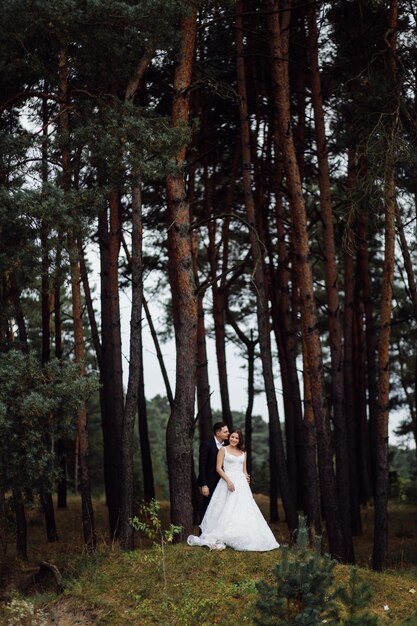 La novia y el novio corren por un bosque Sesión de fotos de boda