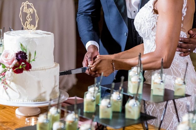 la novia y el novio cortando el pastel de bodas