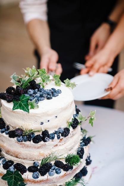 Foto gratuita novia y novio corte pastel de boda con arándanos