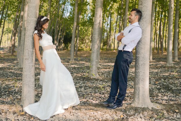 Novia y novio intercambiando miradas en el campo