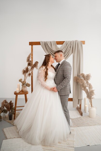 La novia y el novio posan felices juntos después de la ceremonia de la boda