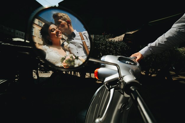 La novia y el novio posando en una moto vintage