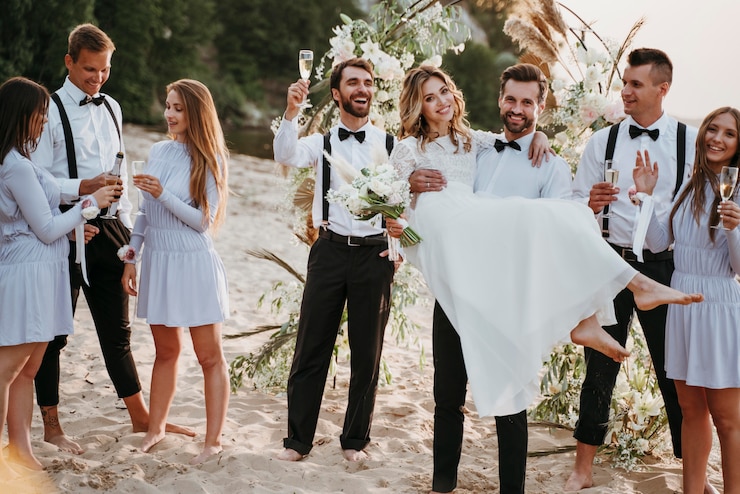 Foto gratuito la novia y el novio en su boda con invitados en la playa