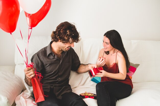 Novia ofreciendo a su novio un bombón de una caja roja
