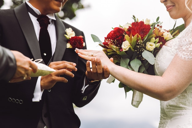 La novia pone el anillo de bodas en el dedo del novio