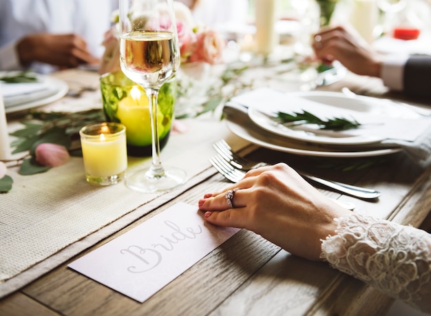 Novia que muestra el anillo de Enagément en la mano izquierda en la celebración de la boda con la familia