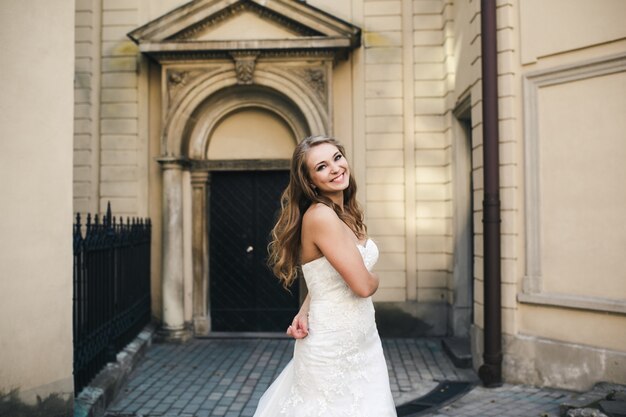 Novia sonriendo con una iglesia de fondo