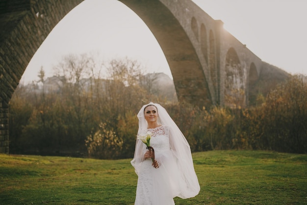 Novia sonriendo bajo un puente