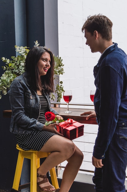 Foto gratuita novia sonriendo con un regalo y una rosa en su mano