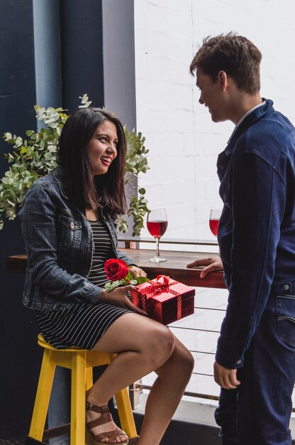 Novia sonriendo con un regalo y una rosa en su mano