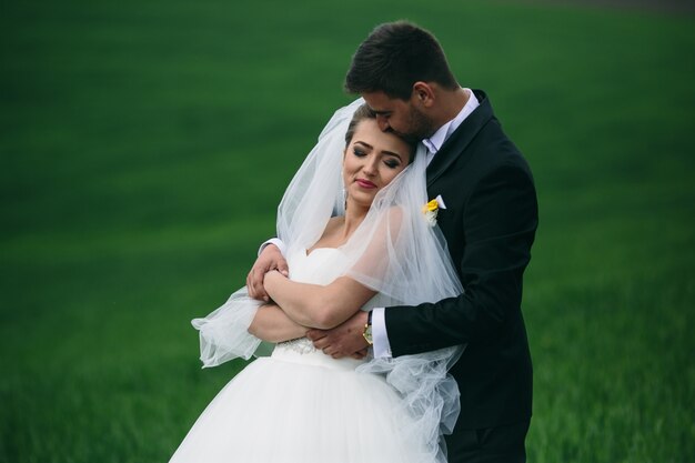 Novia sonriente disfrutando con su marido al aire libre