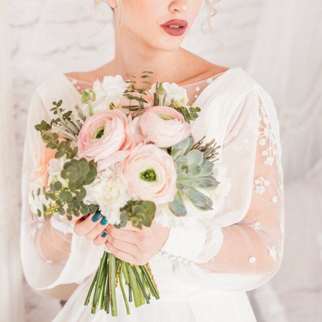 Novia sosteniendo ramo de flores