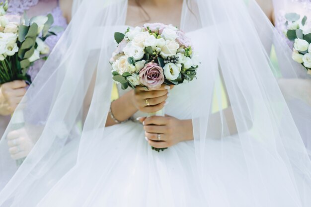 La novia tiene un ramo de novia en sus manos.