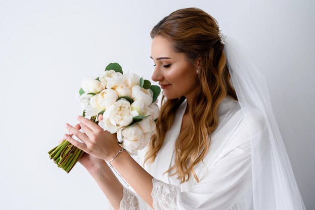 novia en túnica blanca con ramo de flores