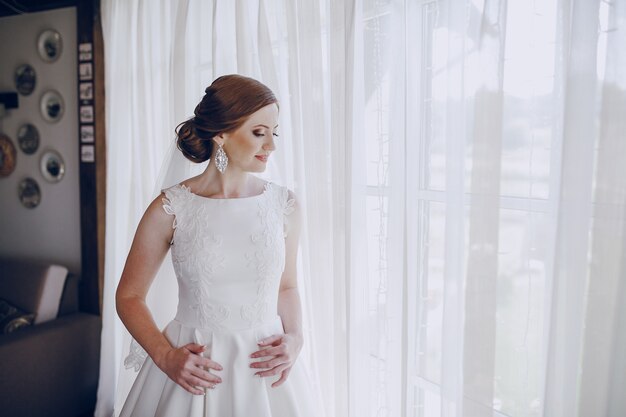 Novia en la ventana con cortinas