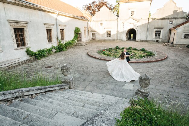 Novias felices bailan cerca del castillo