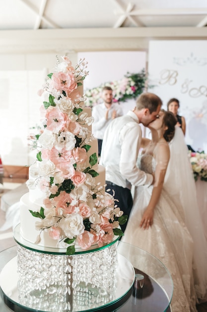 Foto gratuita novias felices besan un pastel el día de su boda