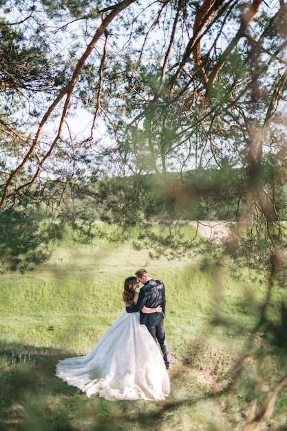 Las novias felices pasan tiempo en el bosque en verano