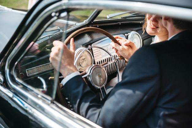 Novias felices viajan en autos retro