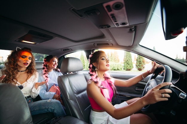 Las novias modernas y elegantes van en el auto escuchando música y divirtiéndose juntas. Van de compras por su ciudad. Los amigos descansan juntos y las compras siempre están juntas.