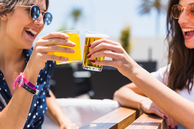 Las novias riendo tintinean vasos con jugo