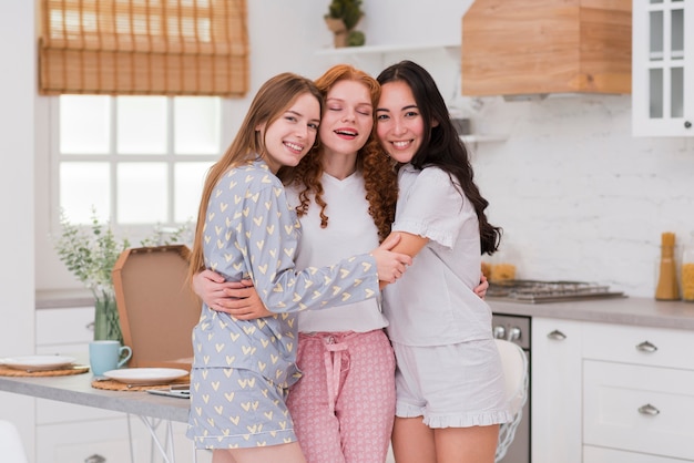 Novias sonrientes en casa abrazando