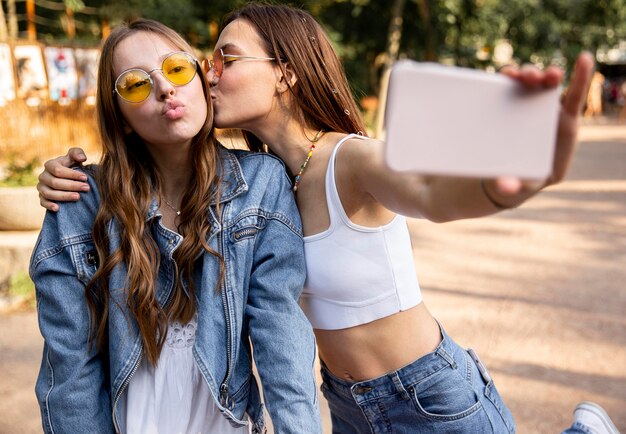 Novias tomando selfie mientras se besan en la mejilla