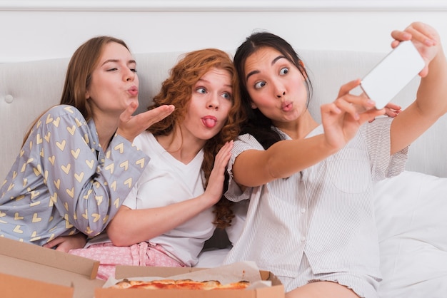 Novias tomando selfies durante la fiesta de pijama