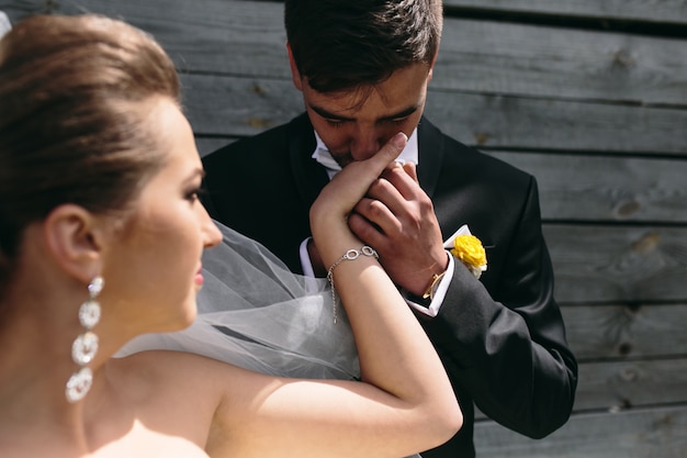 Novio cariñoso besando la mano de su novia