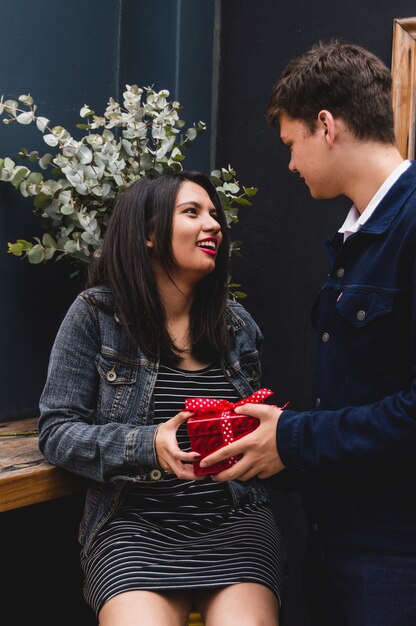 Novio entregando una caja roja de regalo a su novia