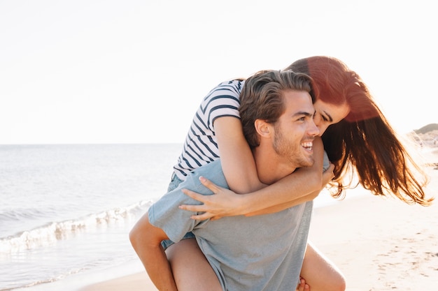 Foto gratuita novio llevando su novia por la playa