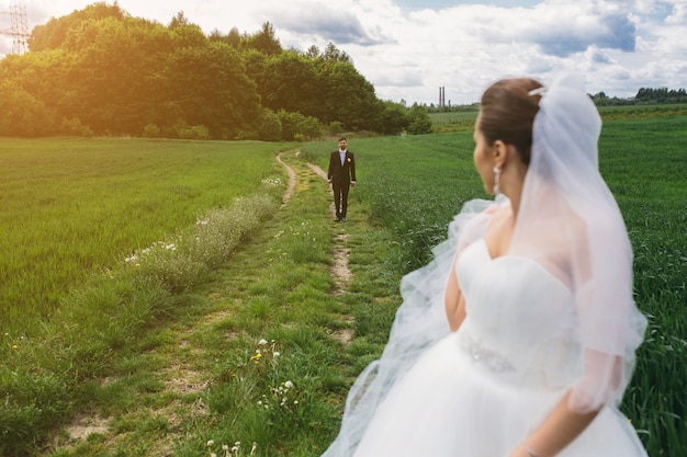 Novio y novia caminando al atardecer