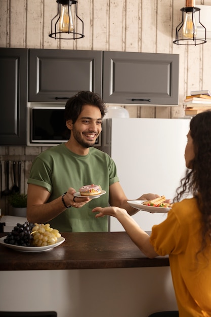 Novio y novia comiendo waffles juntos en casa