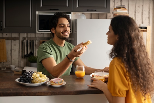 Novio y novia comiendo waffles juntos en casa