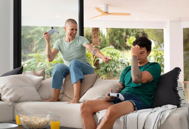 Novio y novia jugando videojuegos juntos en casa