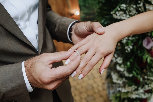 el novio pone el anillo en la mano de la novia en la ceremonia