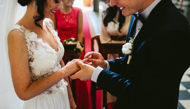 Novio poniendo el anillo en el dedo de la novia
