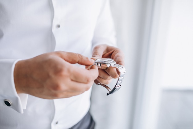 Novio revisando el tiempo en su reloj de pulsera.