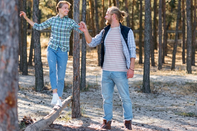 Novio sosteniendo la mano de su novia en la naturaleza