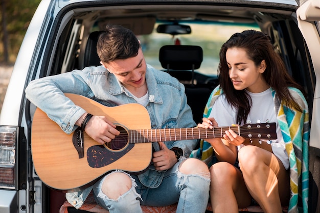 Novio de tiro medio tocando la guitarra