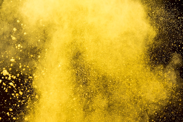 Nube amarilla de polvo cosmético sobre fondo negro