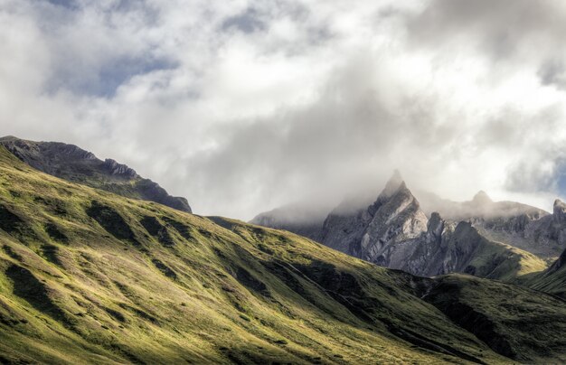 Nubes blancas en la cima de la montaña verde