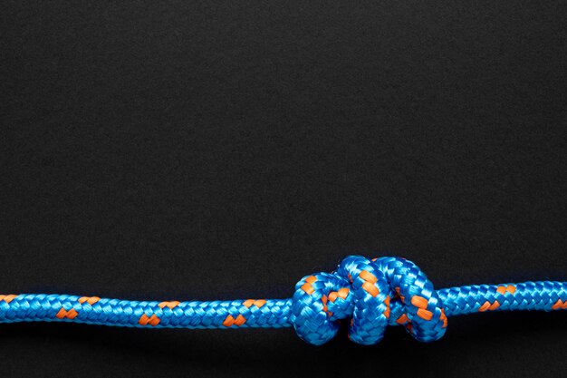 Nudo de cuerda azul fuerte sobre fondo negro copia espacio