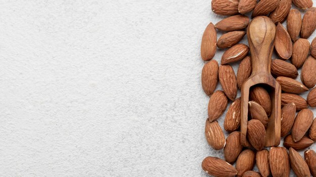 Nueces de almendra orgánica y cuchara de madera