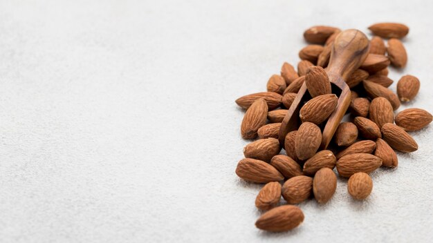 Nueces de almendras orgánicas y espacio de copia de cuchara de madera