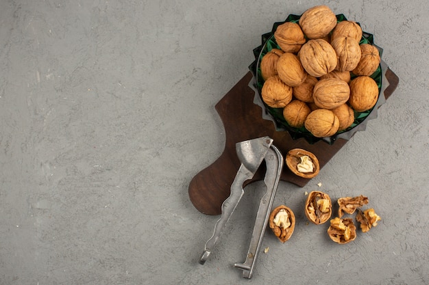 Nueces enteras peladas en un pequeño escritorio marrón y piso gris